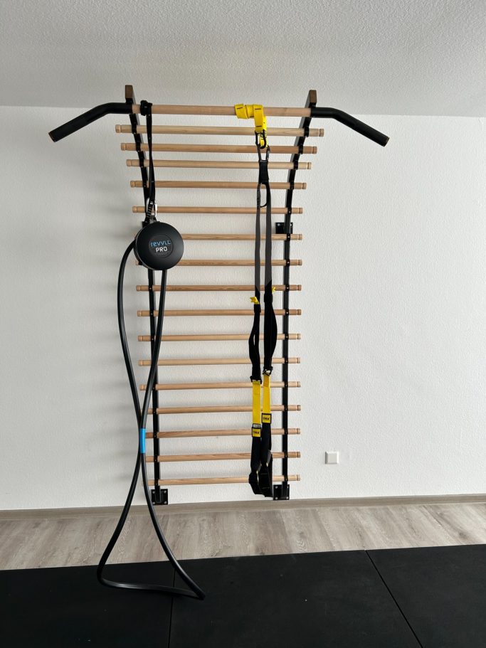 Fitnessgerät mit Sprossenwand, TRX-Bänder und Widerstandsbänder.